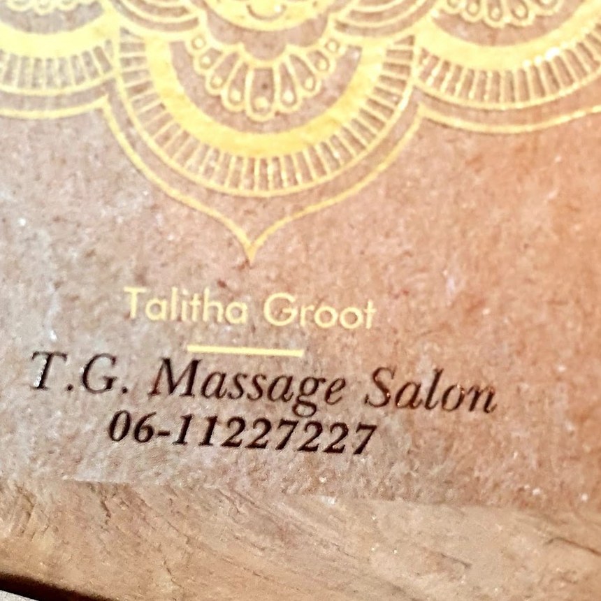 Visitekaartje van T.G. Massage Salon met een gouden mandala op kraftpapier